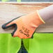 A person holding a pair of Cordova Cor-Tex orange warehouse gloves.