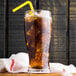A glass of Narvon Old Fashioned Cola with ice and a straw.