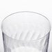 A Fineline clear plastic wine goblet with wavy edges.