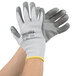 A pair of hands wearing Cordova gray cut resistant gloves with gray tips.
