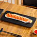 A rectangular matte black stoneware flat plate measuring 14 inches by 6 1/4 inches, shown with sushi on top.