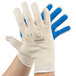 A pair of Cordova work gloves with blue nitrile coating on the palms and white cotton on the back.