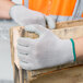 A hand wearing a Cordova Cor-Grip III glove holding a piece of wood.