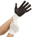 A person wearing Cordova work gloves with black PVC palm coating.