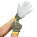 A pair of extra large Cordova Power-Cor Max cut resistant gloves with yellow and green trim on a person's hands.
