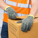 A person wearing Cordova Power-Cor Max Camo cut resistant gloves holding a box.