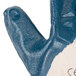 A close up of a blue Cordova nitrile glove with a white jersey lining.
