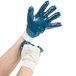 A pair of hands wearing Cordova blue gloves.