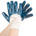 A pair of hands wearing blue Cordova warehouse gloves.