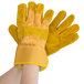A pair of Cordova yellow canvas work gloves with russet leather palms and rubber cuffs.