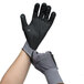 A pair of gray Cordova Conquest gloves with black and gray accents on the palms and nitrile dots on the fingers worn on a pair of hands.