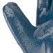 A close up of a blue Cordova Smooth Supported Nitrile glove with a plastic handle inside.