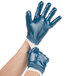 A pair of hands wearing blue Cordova nitrile gloves with white jersey lining.