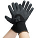 A pair of hands wearing black Cordova Cor-Touch gloves with black foam nitrile and nitrile dots.