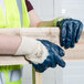 A person wearing Cordova blue gloves holding a piece of wood.