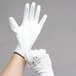 A pair of hands wearing Cordova white gloves with white polyurethane palm coating.