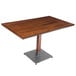 A Lancaster Table & Seating solid wood dining table with a live edge and a metal base.