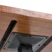 A close up of a Lancaster Table & Seating live edge wood table with metal legs.