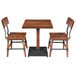 A Lancaster Table & Seating solid wood live edge table with two chairs.