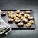 A Matfer Bourgeat aluminum sheet pan with brown and white square cookies on it.
