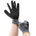 A pair of hands wearing black and gray Cordova Cor-Touch grip gloves.