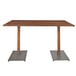 A Lancaster Table & Seating antique walnut live edge bar height table with two metal legs.