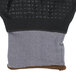 A close up of a gray Cordova glove with black and brown coating and nitrile dots.