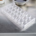 A clear plastic tray with oval-shaped cups in it.