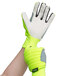 A close-up of a person wearing Cordova Colossus IV Hi-Vis lime gloves with canvas palm coating.