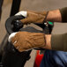 A man wearing Cordova leather driver's gloves on a machine.