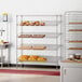 A Regency chrome wire shelving rack with bread on it.