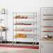 A Regency chrome wire shelving rack holding baking pans and other kitchen items.