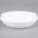 A white Fineline oval Luau bowl on a gray surface.
