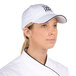 A woman wearing a white Chef Revival baseball cap with a black logo.