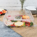 A Fineline clear plastic square cater tray with vegetables and dip on a table.