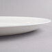 A white Fineline oval plastic catering tray with a rim.