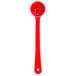 A red Carlisle long handled portion spoon with perforations.