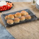 A clear plastic rectangular dome lid on a tray of rolls and vegetables.