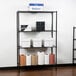 A 360 Office Furniture black wire shelving unit with boxes and paper towels on the shelves.