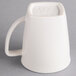 A Hall China bright white mug with a handle.