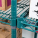 A green Metro Super Erecta wire shelf with boxes on it.