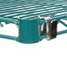 A close-up of a green metal rack shelf with a metal clip.
