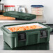 A green Cambro Ultra Pan Carrier with food inside.