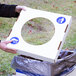 A person putting a white square lid with a circle cut out on a white box.