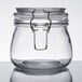A close up of a Choice clear glass storage jar with a metal hinge top.