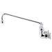 A silver T&S wall mount faucet with long metal lever handles.