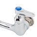 A T&S chrome wall mounted faucet with lever handles and blue buttons.