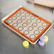 A Sasa Demarle SILPAT half size baking mat with macarons on a counter.
