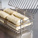 A Tablecraft burrito fryer basket with food on a rack.