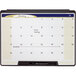 A Quartet portable monthly calendar whiteboard with a black plastic frame and writing on it.